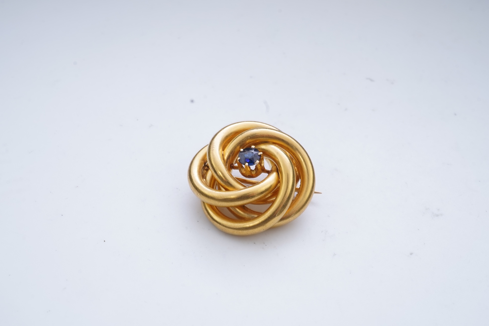 A gold and sapphire knot brooch, France, late 19th century
